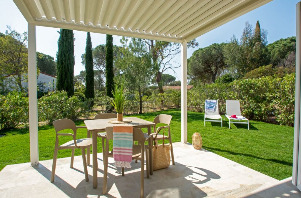 Covered terrace with pergola and garden furniture in front of an Oasis Village accommodation in Puget-sur-Argens